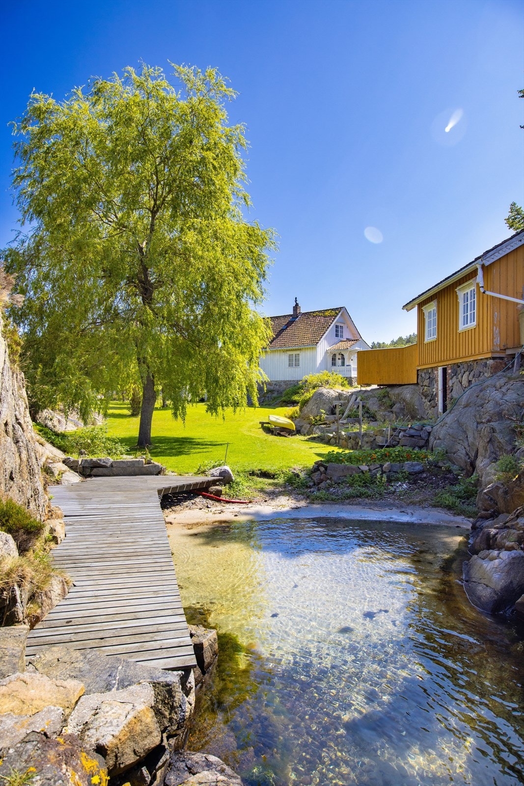 Her er det sandstrand og gangbrygge som fører til lun uteplass mot vest. Galleribilde