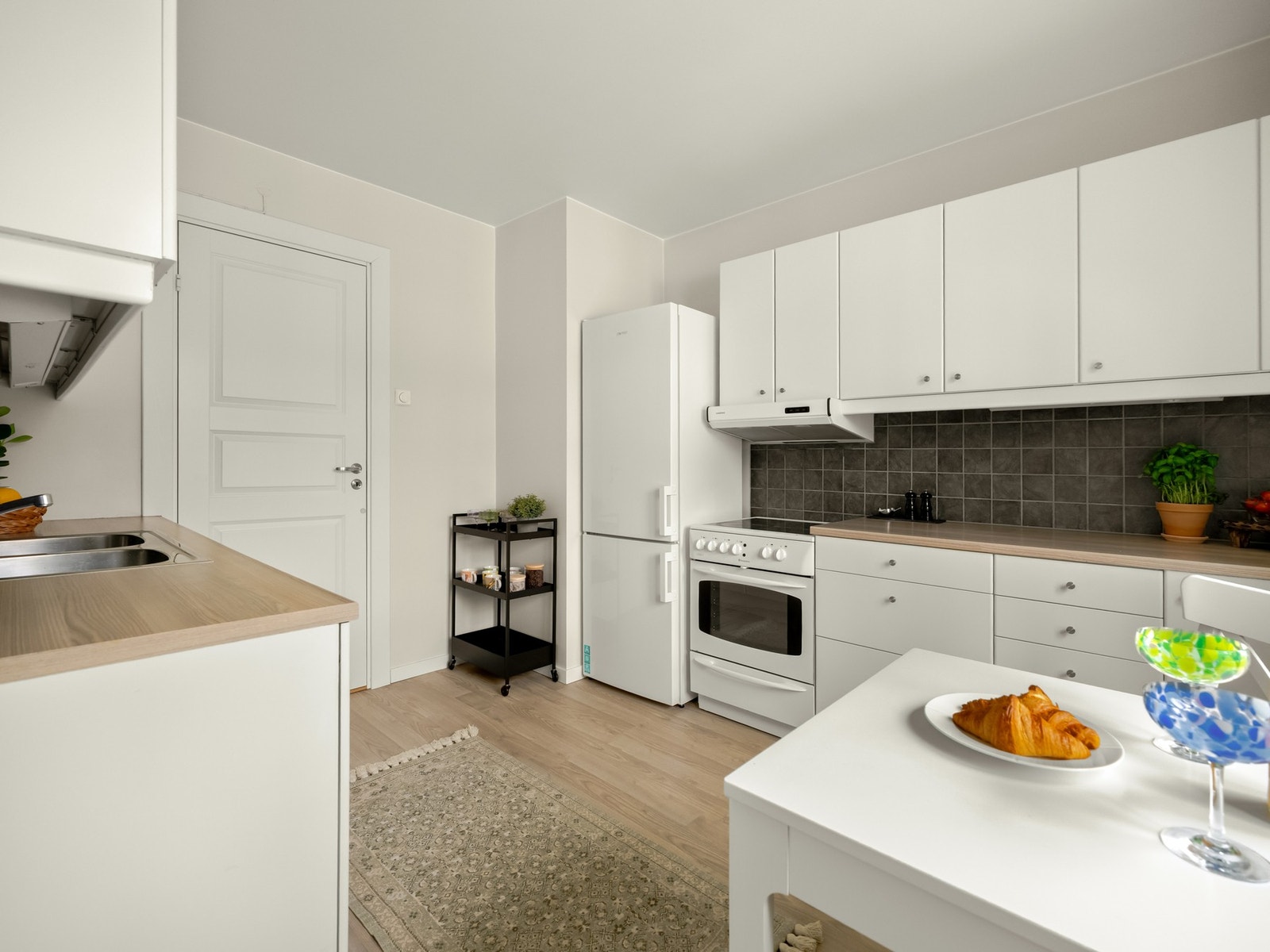 Innredningen består av glatte fronter med stålknotter, laminat benkeplater og frittstående komfyr og kjøleskap. Galleribilde