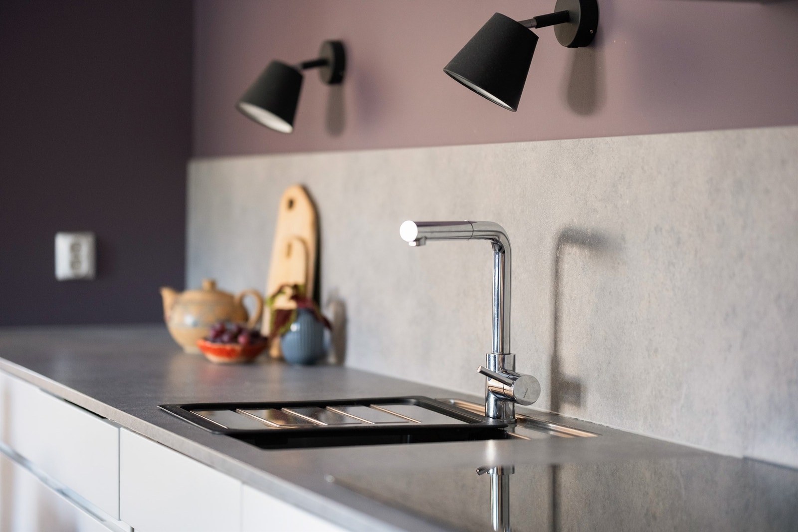 Platetopp og vask av underlimt modell er praktisk plassert side om side, omgitt av brede arbeidsflater. Galleribilde