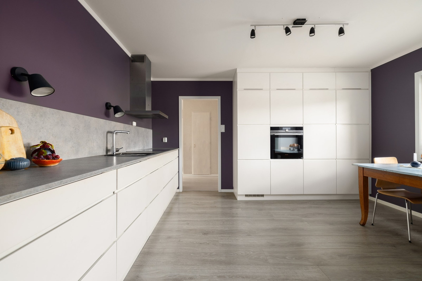 Kjøkkenets omfangsrike innredning har både stilsikker fremtoning og mange oppbevaringsmuligheter. Hvitevarer utenom kjøleskap er integrert. Galleribilde