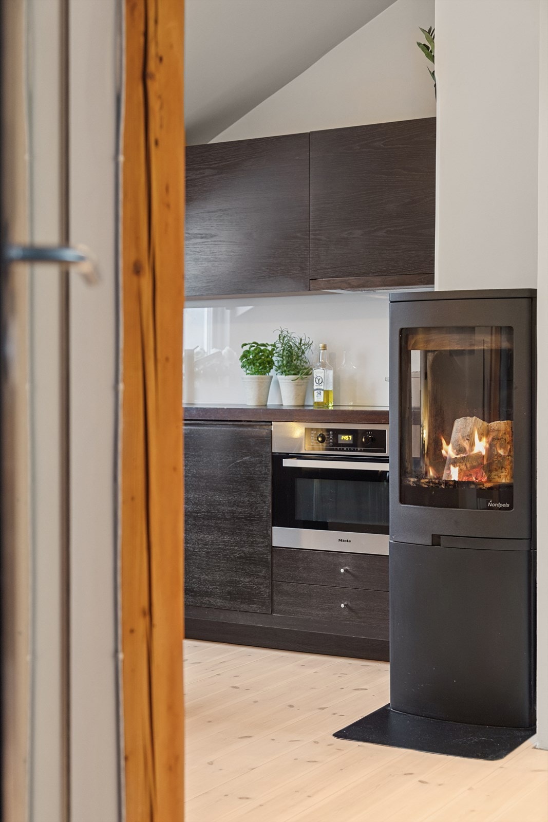 Sentralt plassert i rommet finner du en trivelig vedovn med glassdør som sørger for ekstra varme og hygge på kalde dager. Galleribilde