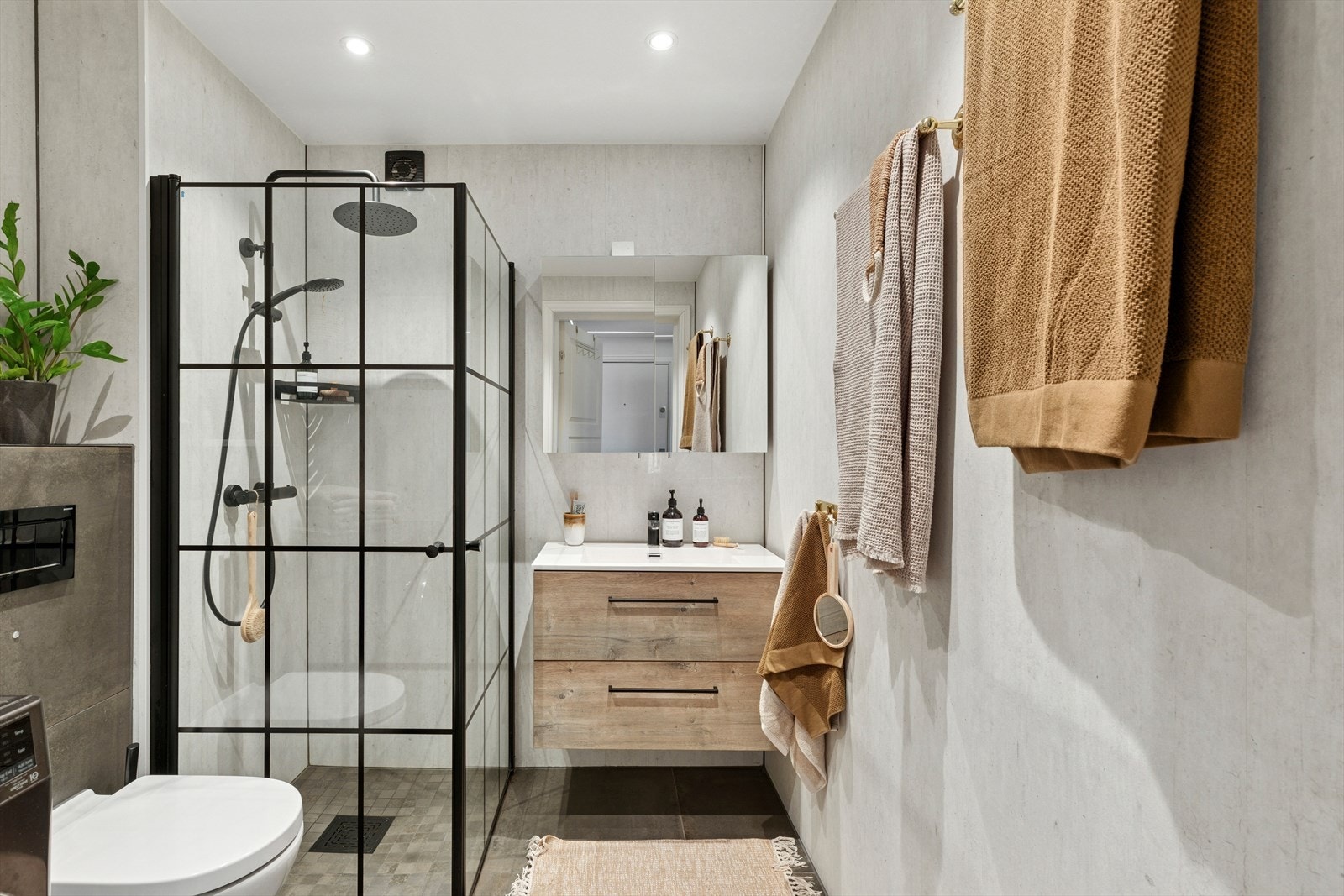 Baderommet har innredning med nedfelt servant, veggmontert toalett, dusjvegger/hjørne og opplegg for vaskemaskin. Galleribilde