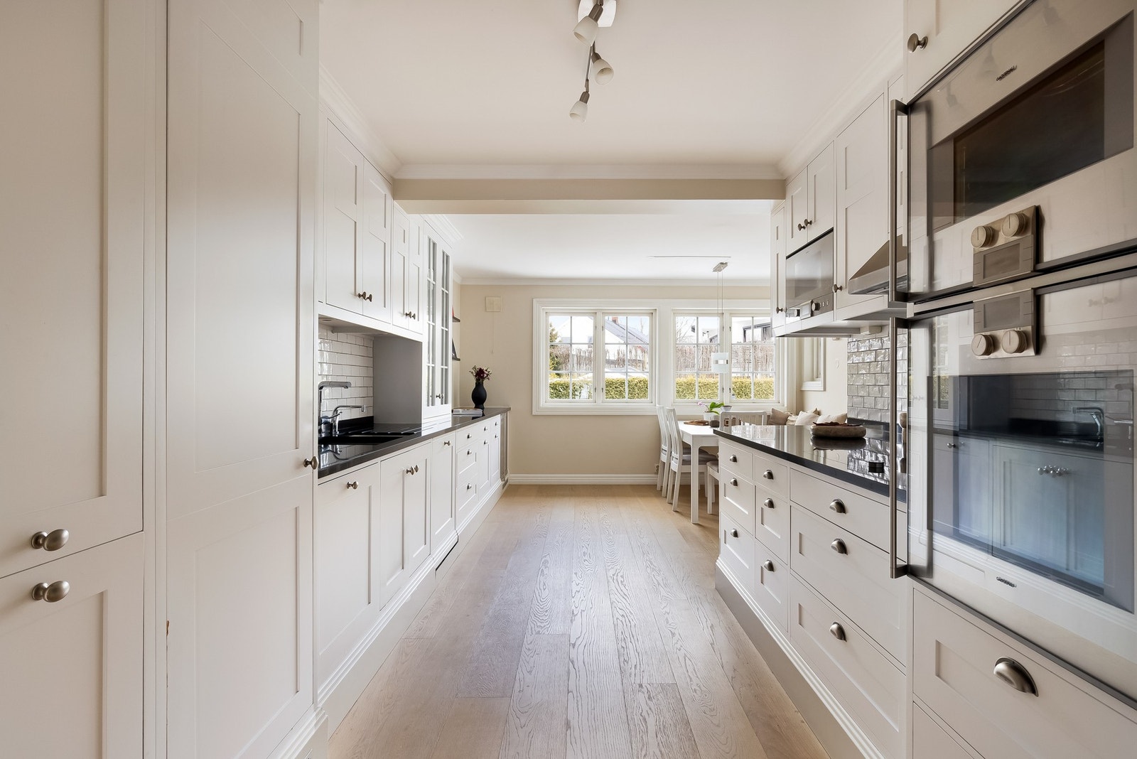 Fra entreen er det en glassdør inn til et lekkert kjøkken med tidløst og velholdt innredning fra 2010, spekket med gode løsninger, massevis av benkeplass og høykvalitetshvitevarer. Galleribilde
