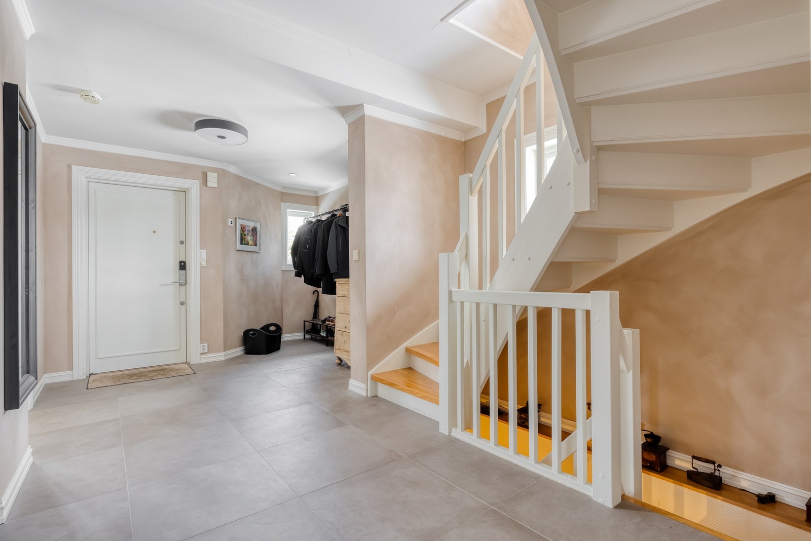 Fra inngangspartiet møtes du av en stor og romslig hall med grå 60X60 fliser på gulv og deilig gulvvarme samt malte vegger. Galleribilde