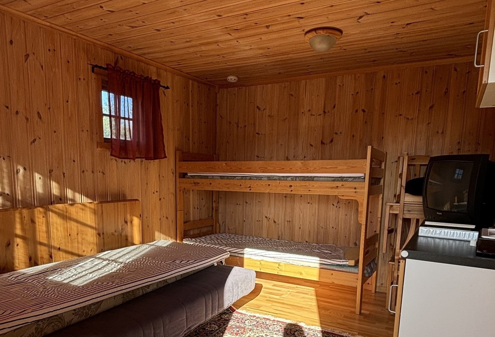 Annekset er av god størrelse og har plass til fleresengeplasser og evt. sofaløsning. Her finner man også en enkel kjøkkenkrok med kjøleskap og en frittstående koketopp. (Foto: privat) Galleribilde