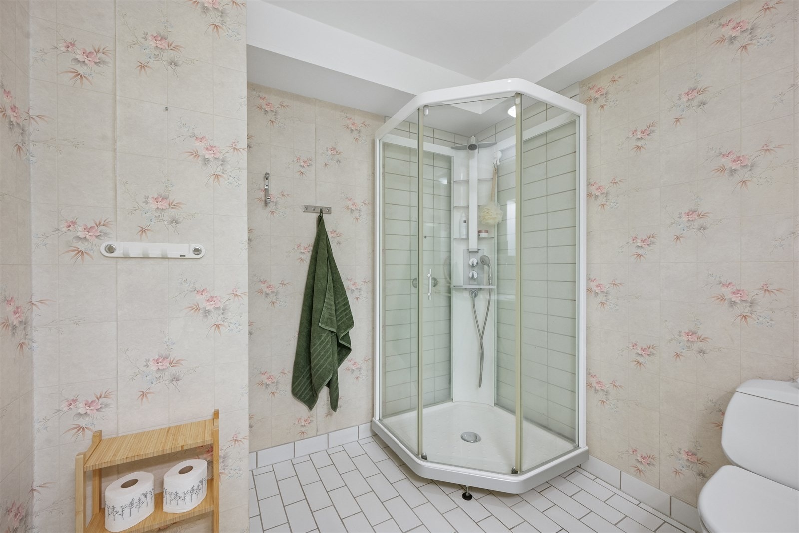 Badet er innredet med dusjkabinett, toalett og servant med innredning. Galleribilde