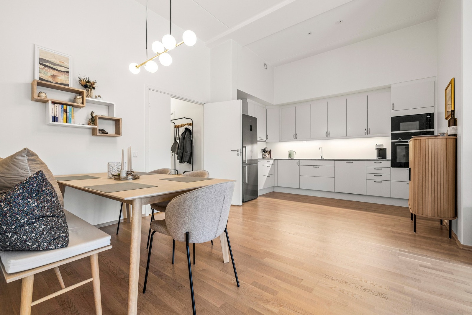 Kjøkkenet ligger i åpen løsning mot stue med glatte fronter, benkeplater av laminat og planlimt oppvaskkum med ett-greps armatur. Galleribilde