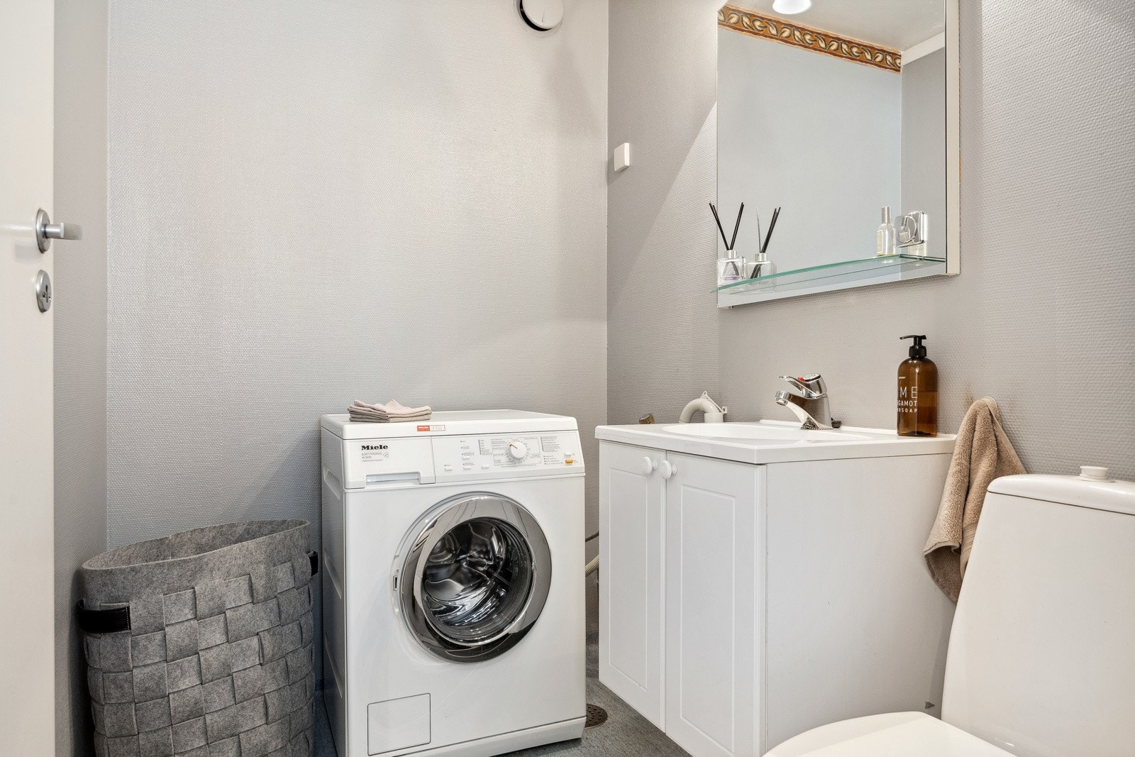 Vegg i vegg med entréen har man et praktisk toalettrom/vaskerom. Flere av beboerne i borettslaget har satt inn dusj på dette rommet, slik at man får ytterligere et fullverdig bad. Galleribilde