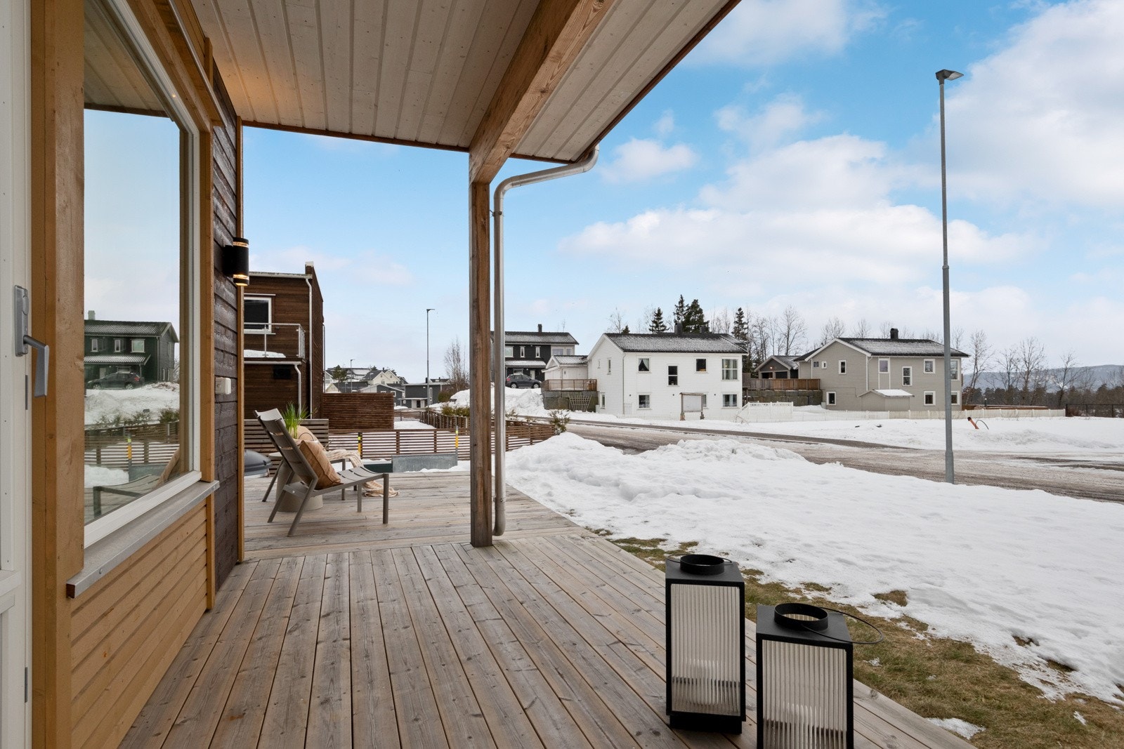 Terrassen har dekke av terrassebord, utebelysning, utestikk og noe overbygg av balkong i etasjen over. Galleribilde