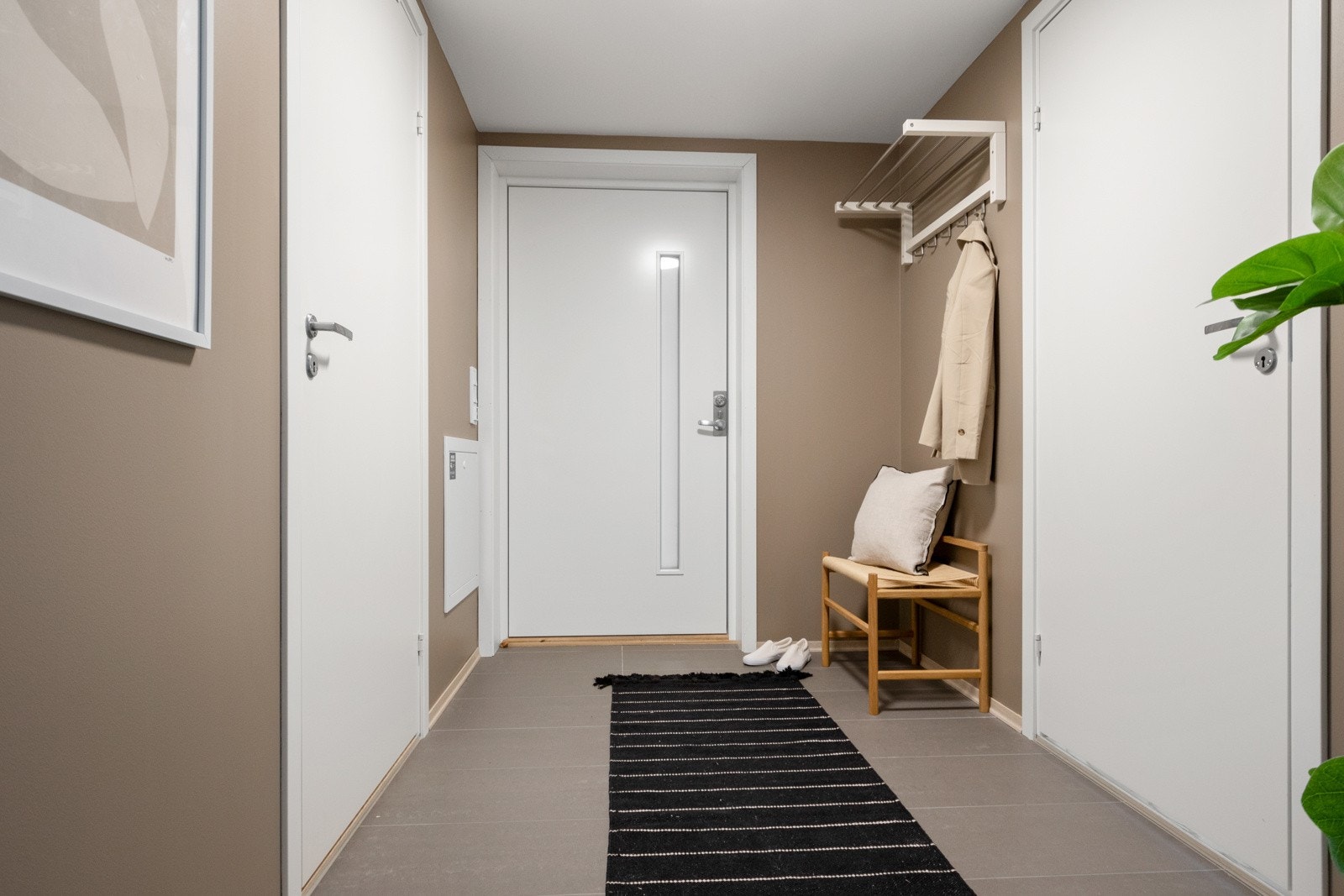 Herfra fører en hvit inngangsdør med glassfelt inn til en innbydende entré. Galleribilde