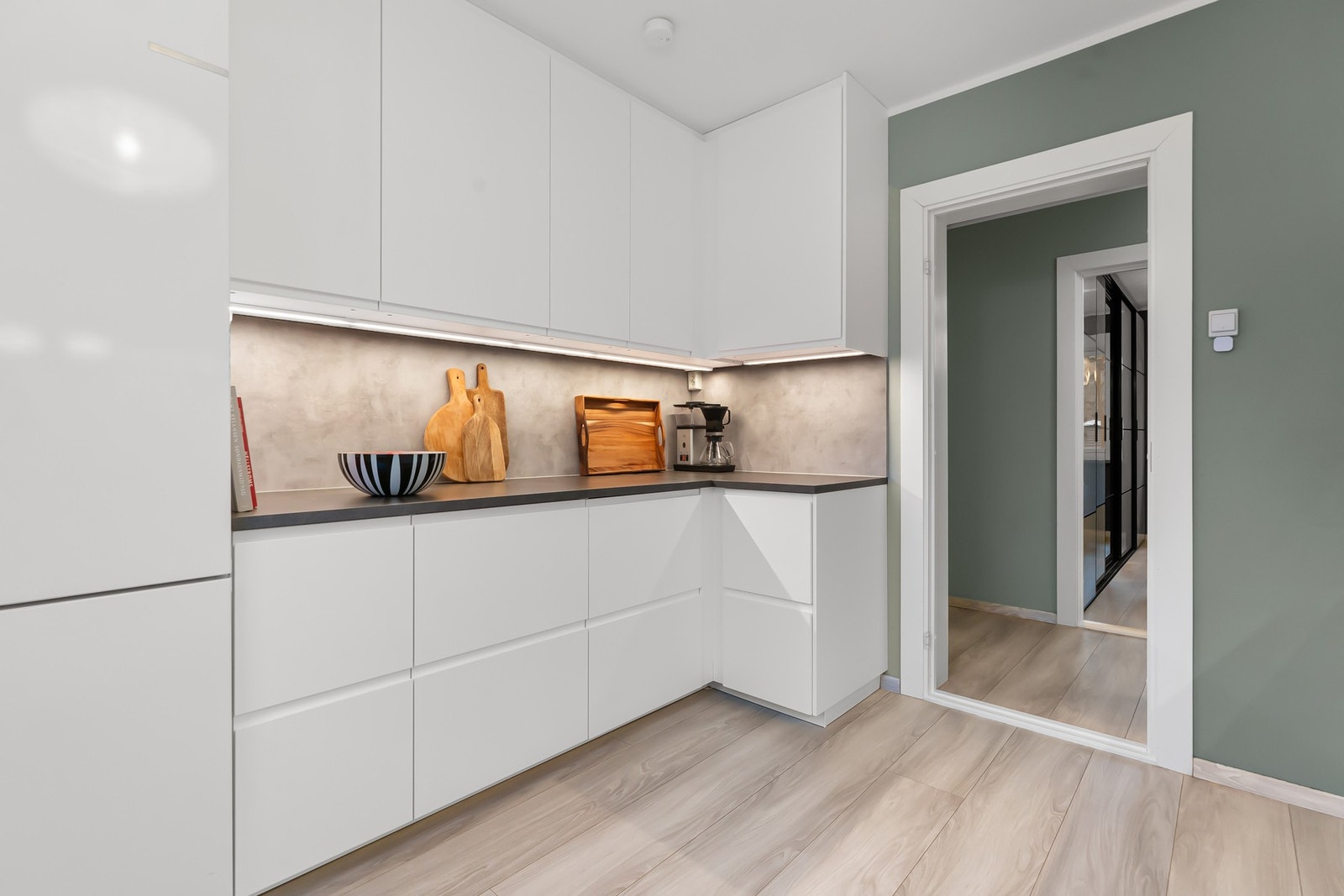 Det er rikelig med skap- og benkeplass på kjøkkenet, og det er montert laminatplater på veggene mellom benk og overskap. Galleribilde