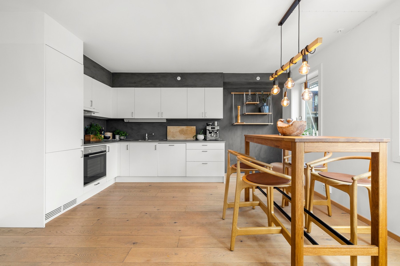 Hvite, glatte kjøkkenfronter kombinert med mørke kontraster gir et tidløst og elegant uttrykk. Galleribilde