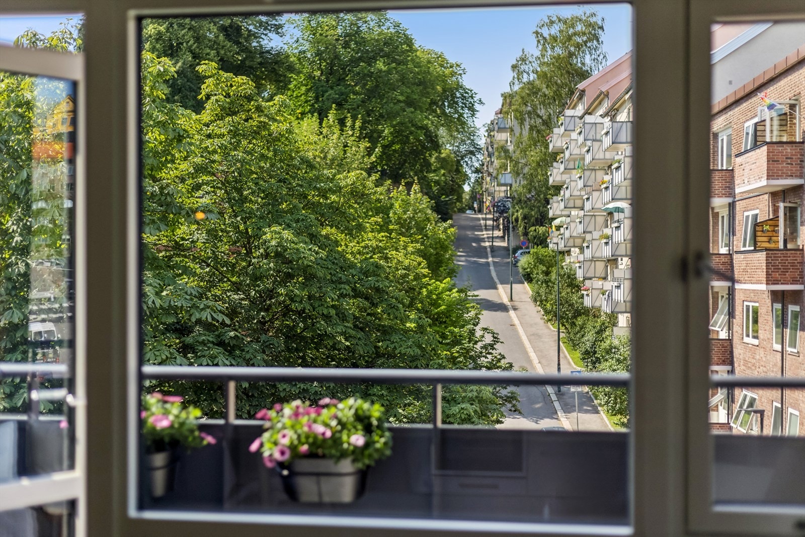 Stuen og balkong vender ut mot frodige grøntarealer og en stille enveiskjørt gate Galleribilde