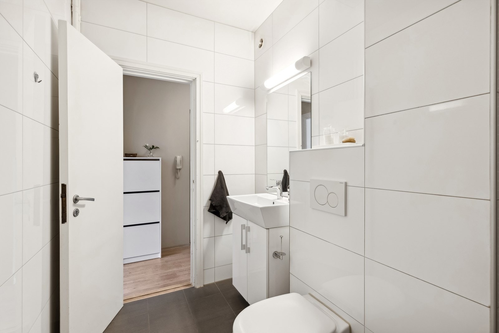 Badet er utstyrt med vegghengt toalett, et romslig dusjhjørne, baderomsinnredning med servant, samt opplegg for vaskemaskin. Galleribilde