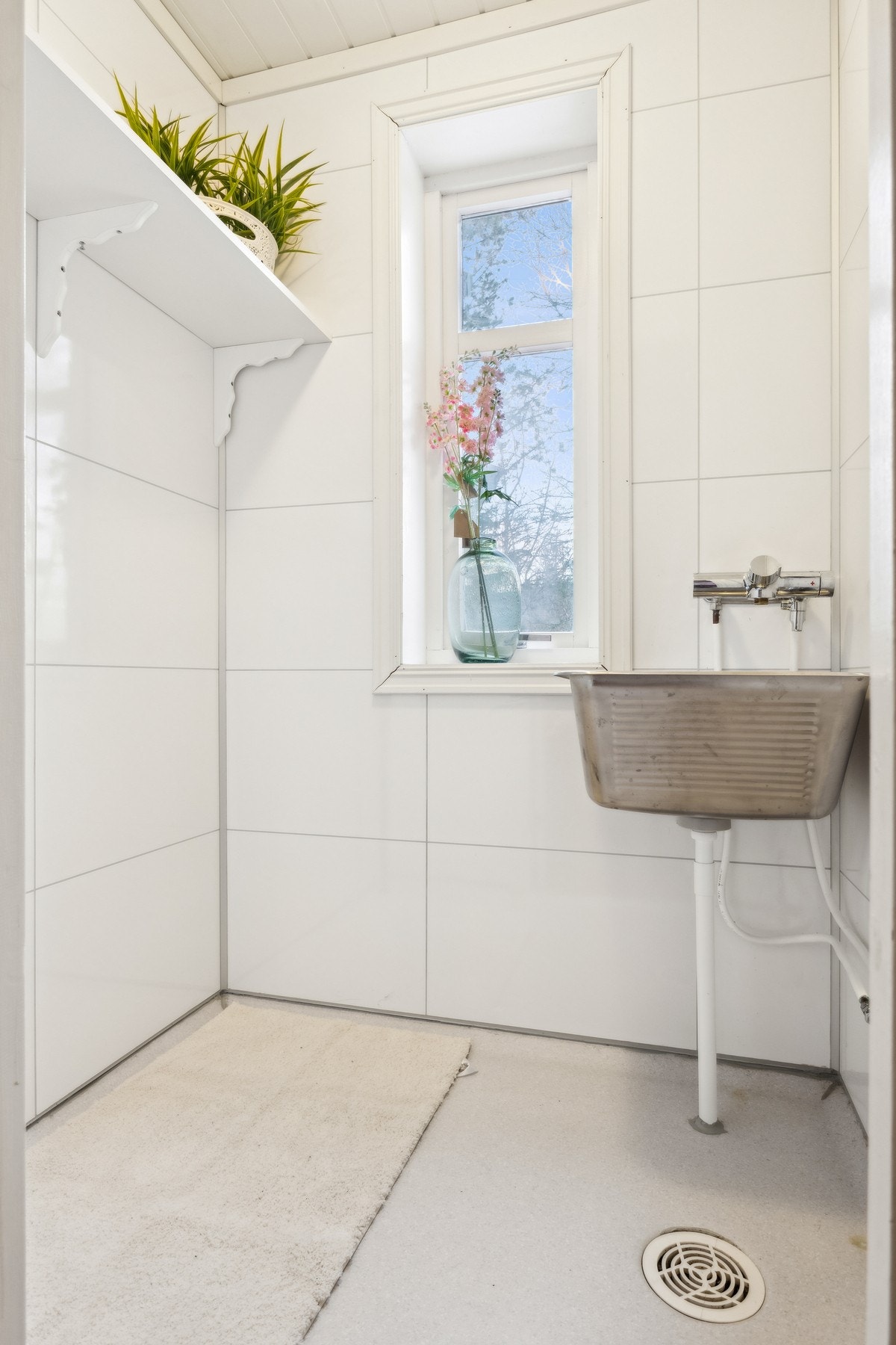 Vaskerommet har baderomsplater på vegg, og vinylbelegg på gulvet, alt fra 2014. Galleribilde