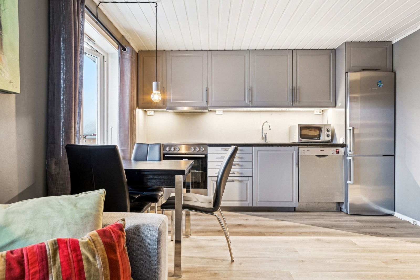 Også her er det åpen stue/kjøkken løsning, lagt laminat på gulvet og vinduene slipper inn rikelig med dagslys. Galleribilde