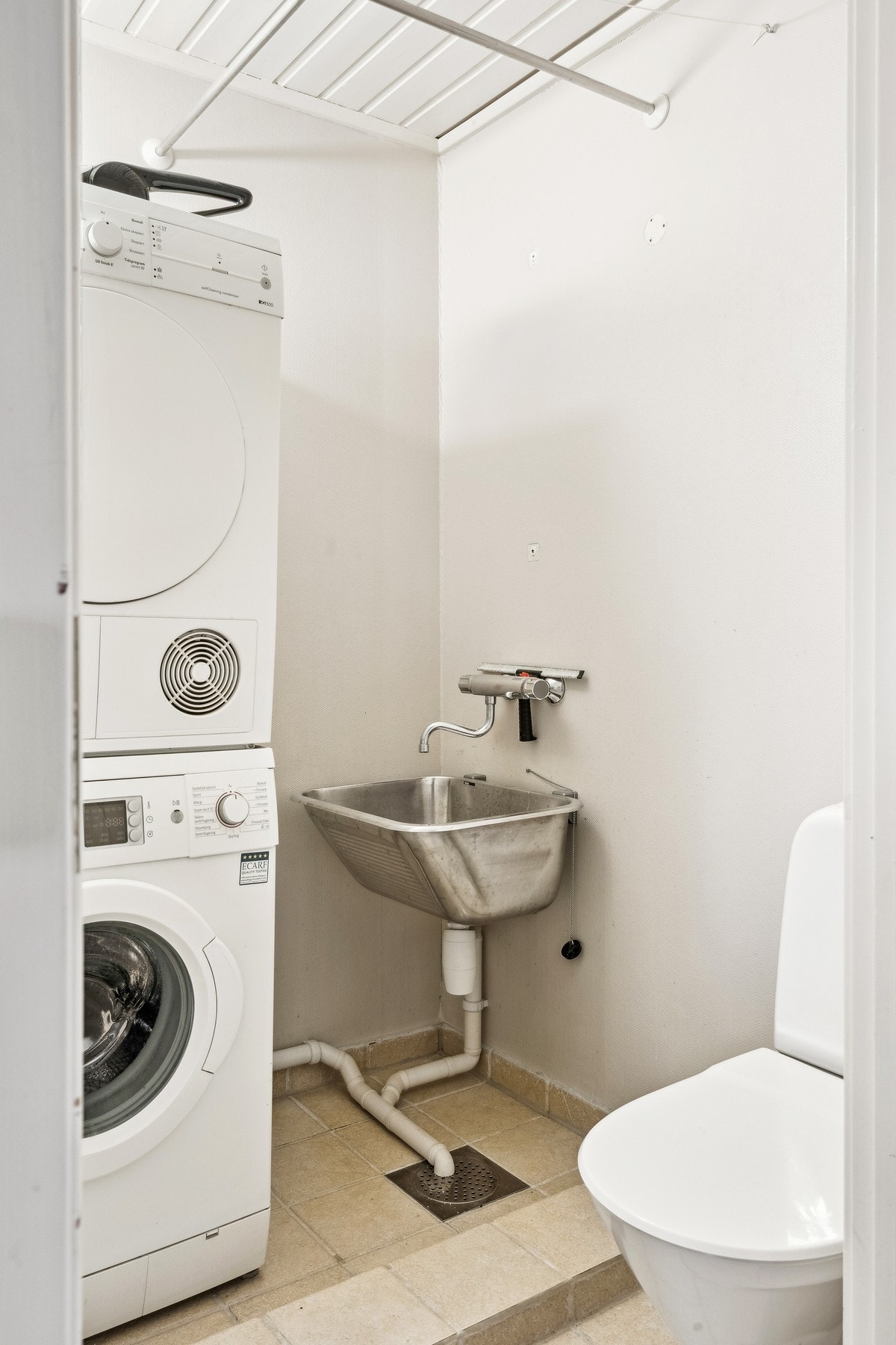 Toalettrom med opplegg for vaskemaskin og skyllekar i stål. Galleribilde