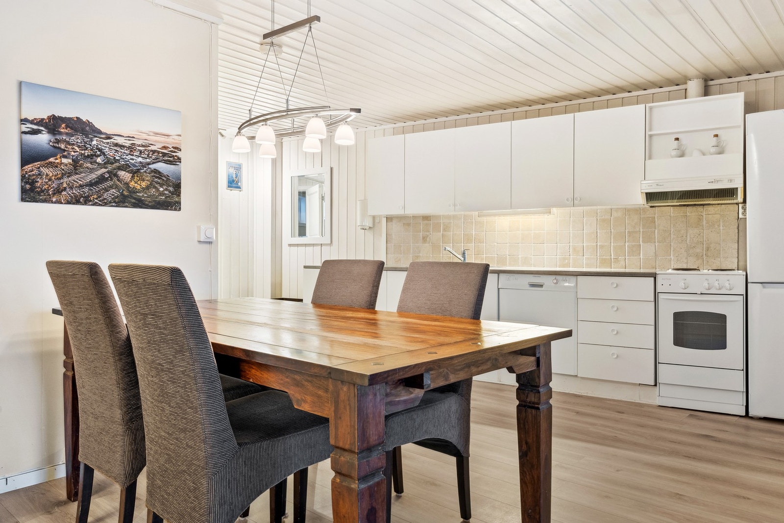 Kjøkken ligger praktisk til i rommet og strekker seg langs den ene veggen. Godt med skap- og benkeplass. Galleribilde