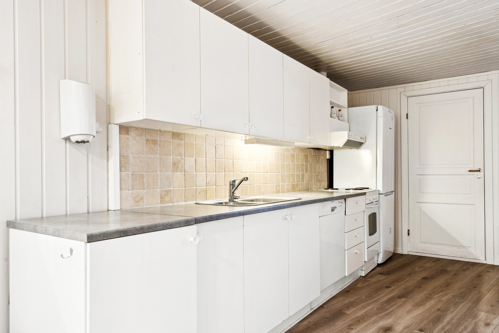 Innredning med slette hvitmalte fronter og laminat benkeplate. Samt nisje for oppvaskmaskin. Galleribilde