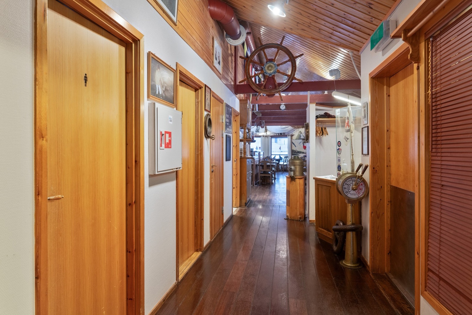 Gang til restauranten med skipspreget innredning som gir en god atmosfære for gjester med engang. Toalett til venstre. Galleribilde