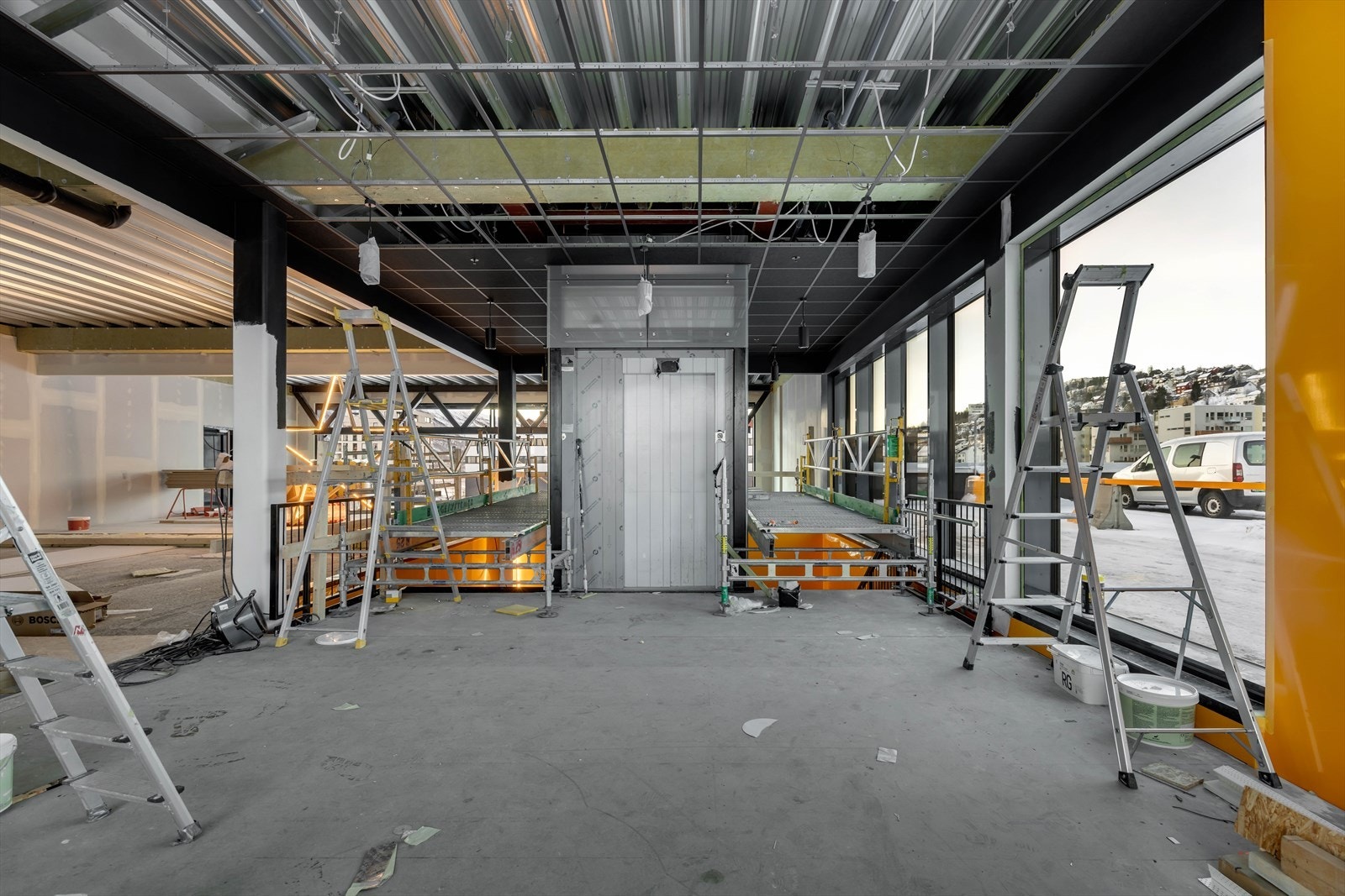 Heis og trapper ned til første etasje. Moderne lokale med store vindusflater og spennende design. Galleribilde