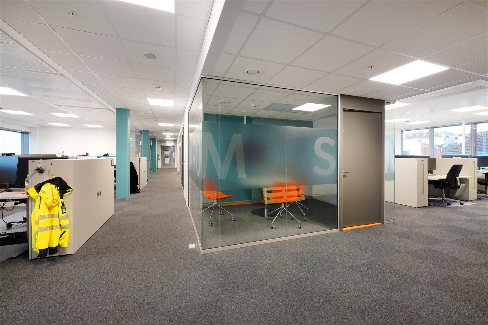 Lyst og moderne kontorlokale med åpne arbeidsplasser. Store vinduer som gir rikelig med naturlig lys. Galleribilde