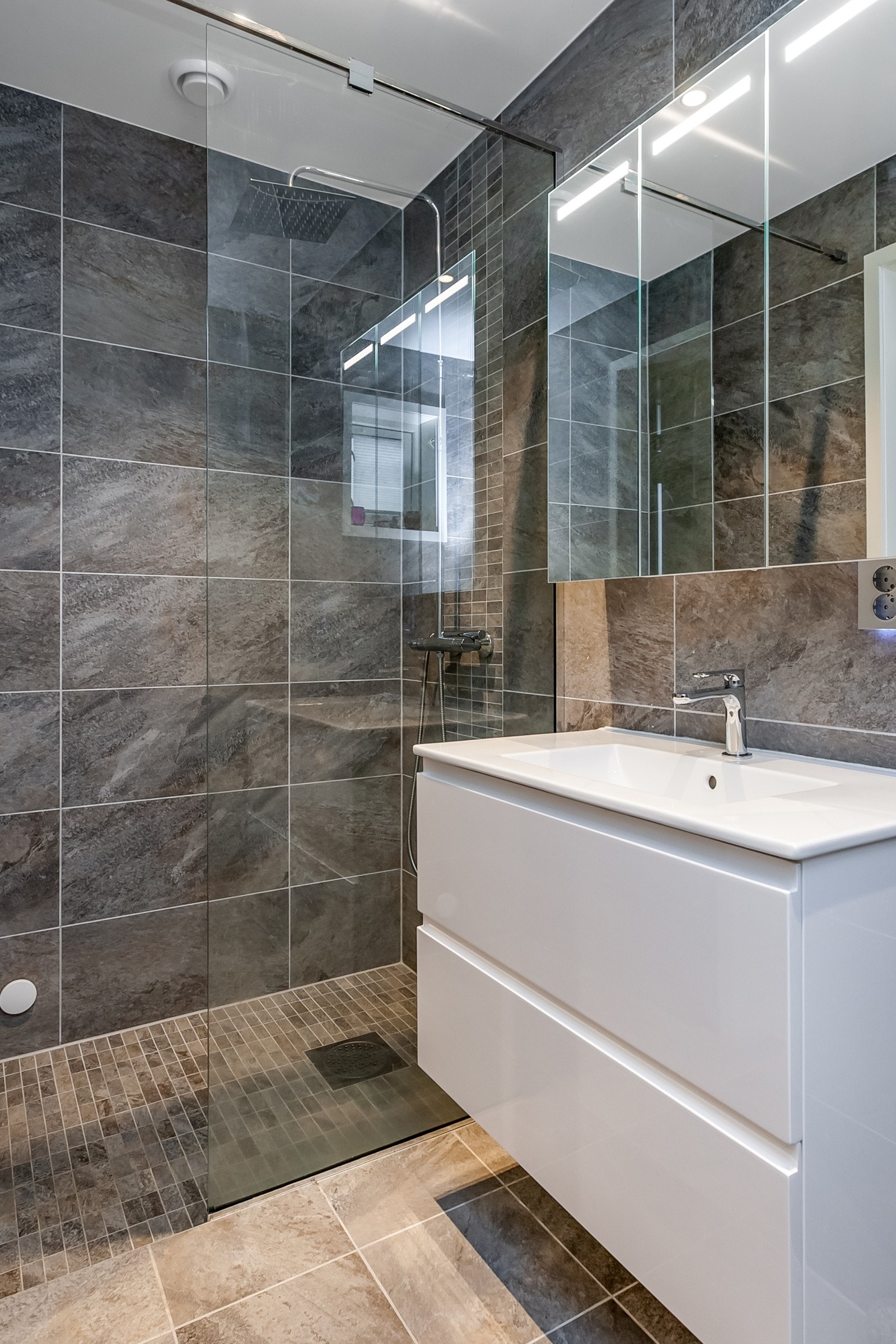 Bad i 1. etg. som har dusjsone, toalett, innredning og opplegg til vaskemaskin. Galleribilde