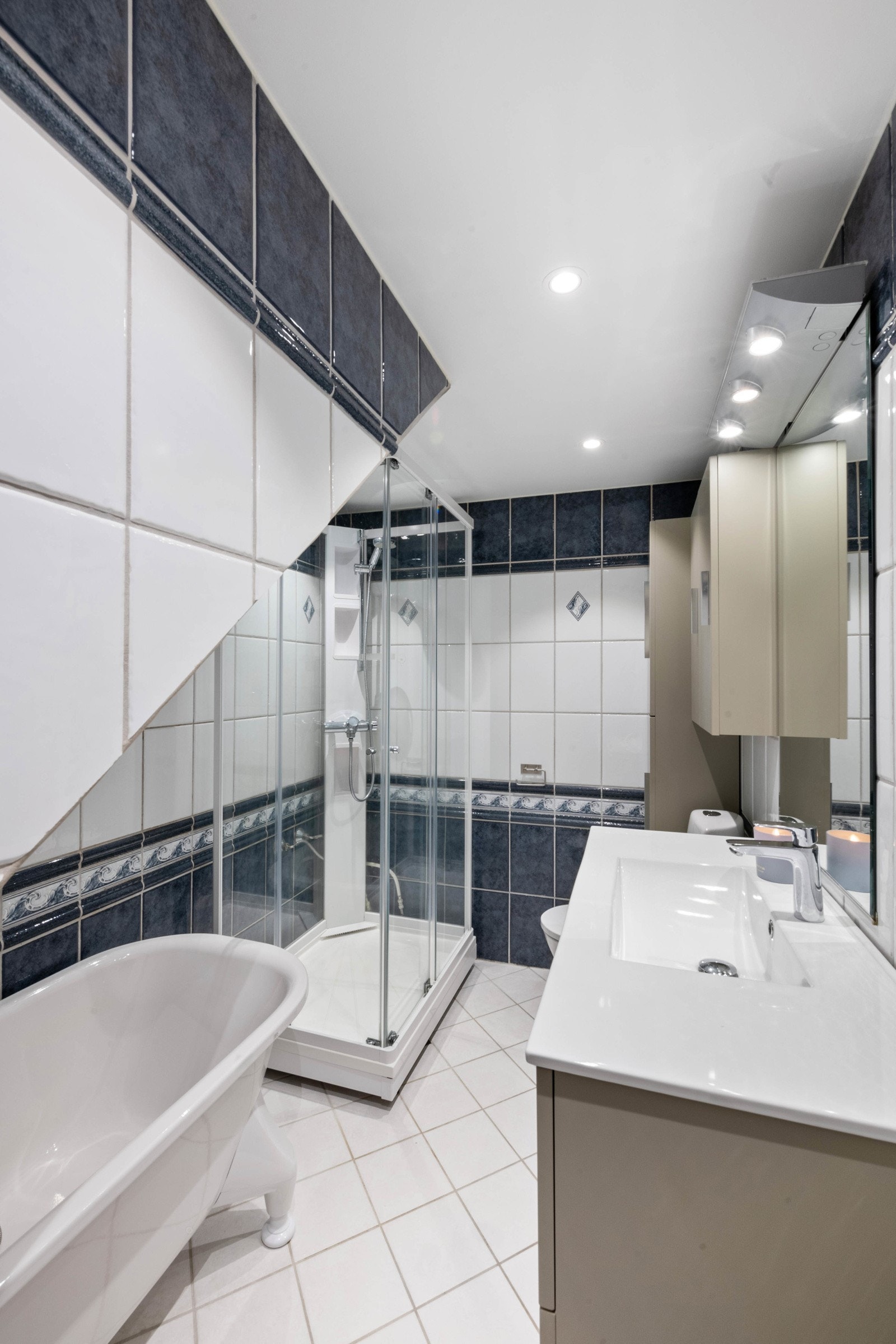 Badet har flislagte vegger og gulv med behagelig gulvvarme fra 1999. Delvis oppusset tak i 2017 med bl.a. 4 LED downlights. Frittstående badekar, dusjkabinett fra 2021, servantskap fra 2021 med 2 store skuffer, glatte fronter og heldekkende servant. Galleribilde