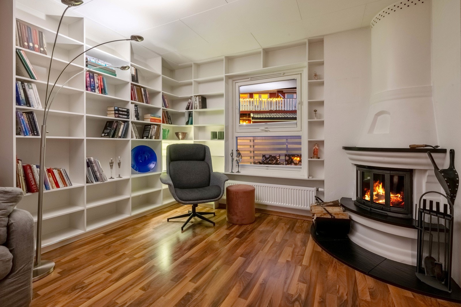 Boligen tilbyr en sjelden kombinasjon med både peisovn og fjernvarme. Plassbygde hyller på 2 av veggene ved peisovnen, gir ekstra godt med oppbevaringsplass. Her kan man enkelt lage et lite bibliotek eller kosekrok. Galleribilde
