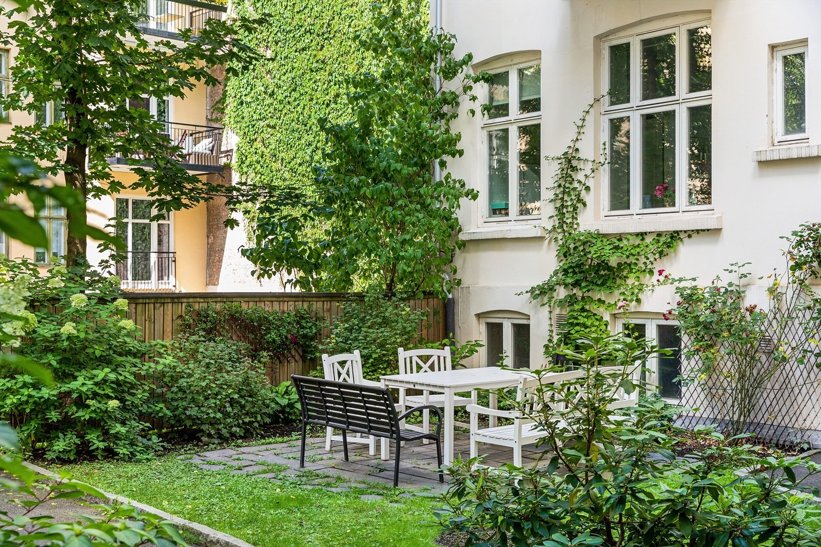 Bakgården har sittegruppe, sykkelparkering og lekeapparater for barn Galleribilde