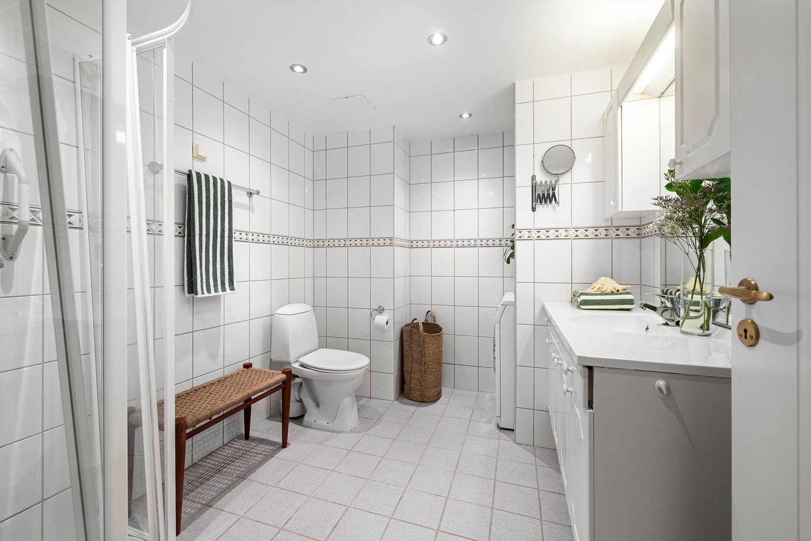 Bad fra byggeår med flislagte overflater, downlights i himling og elektriske varmekabler. Galleribilde