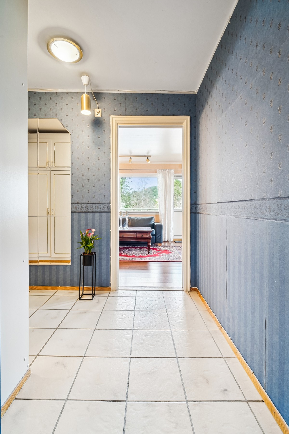 Romslig flislagt entré/gang med tapet på vegger. Galleribilde