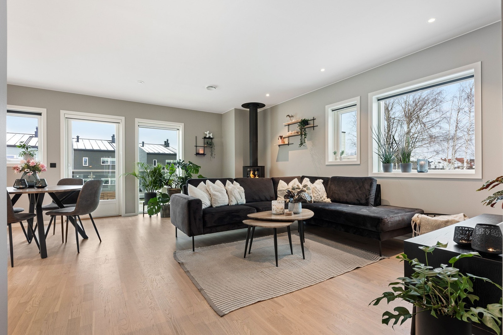 Lys og romslig stue med store vindusflater. Åpen løsning mot spiseplass. Moderne peis og lyst tregulv. Galleribilde