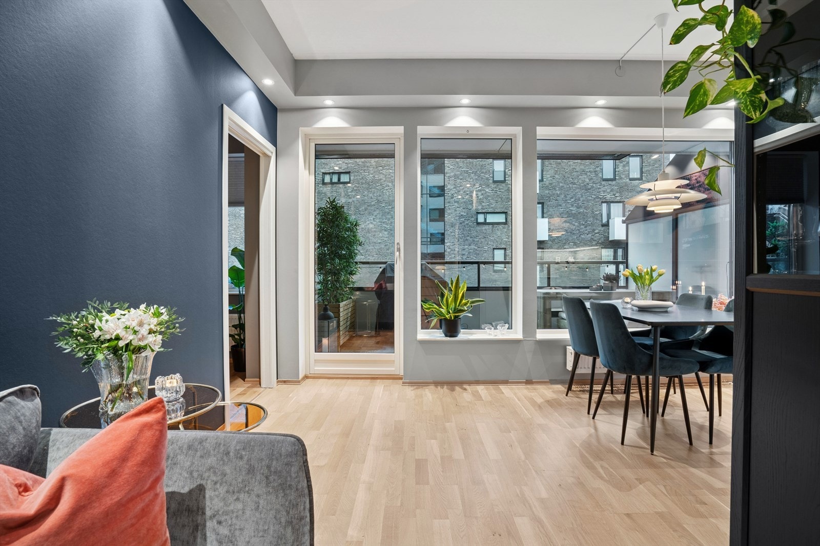 Dagslyset strømmer inn fra to større vinduer og en glassdør ut mot en vestvendt balkong. Galleribilde