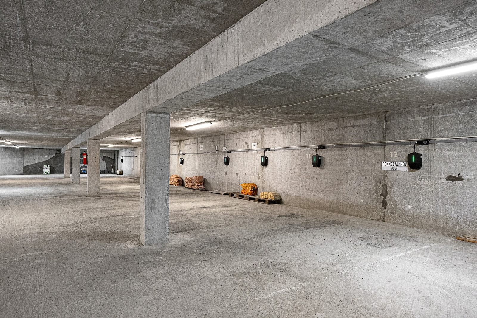 Garasjeanlegg. Det er montert elbil-lader på leilighetens parkeringsplass Galleribilde