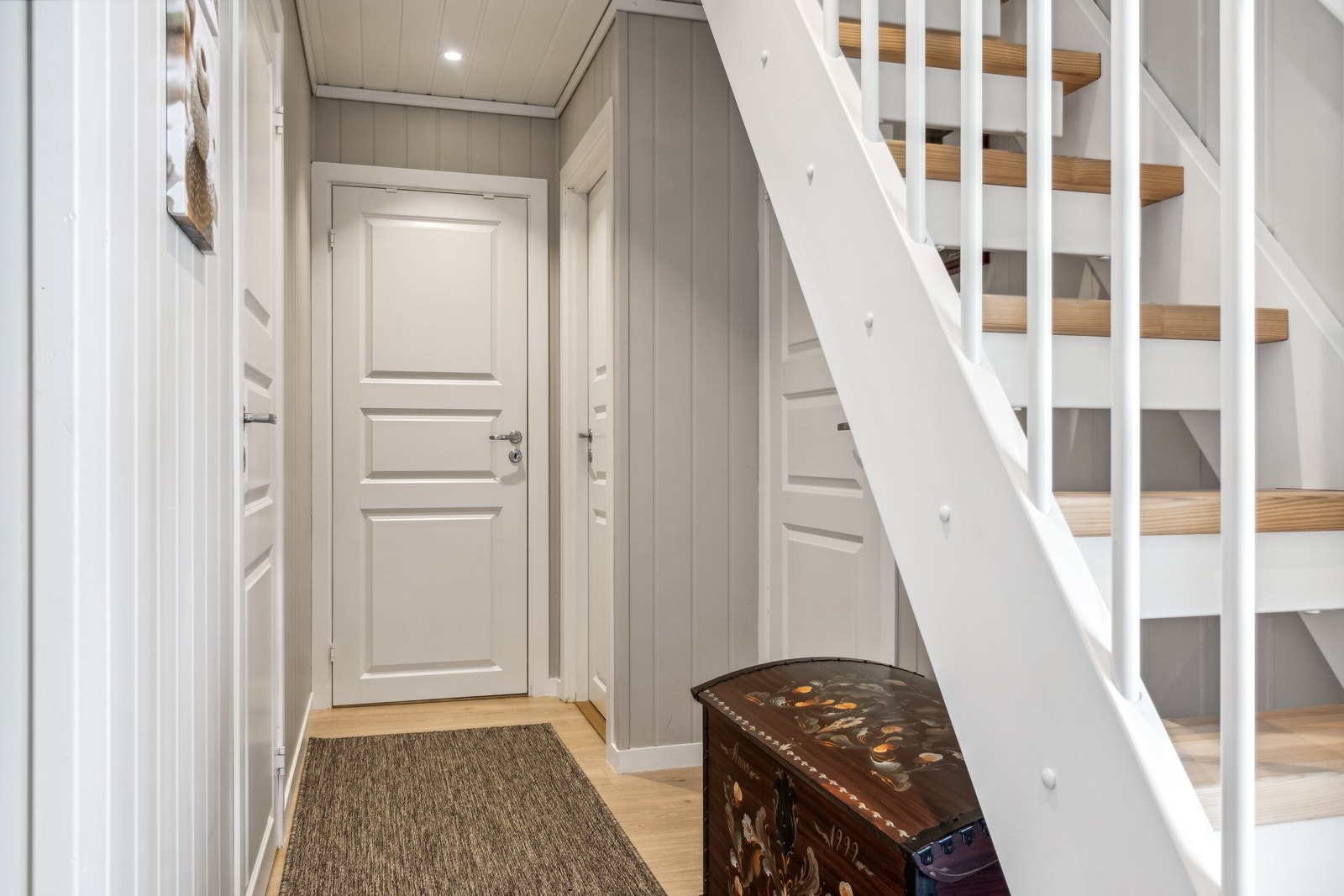 Entreen ligger i tilknyting til en gang, og begge rommene er utstyrt med gulvvarme. Trapp opp til hems. Galleribilde