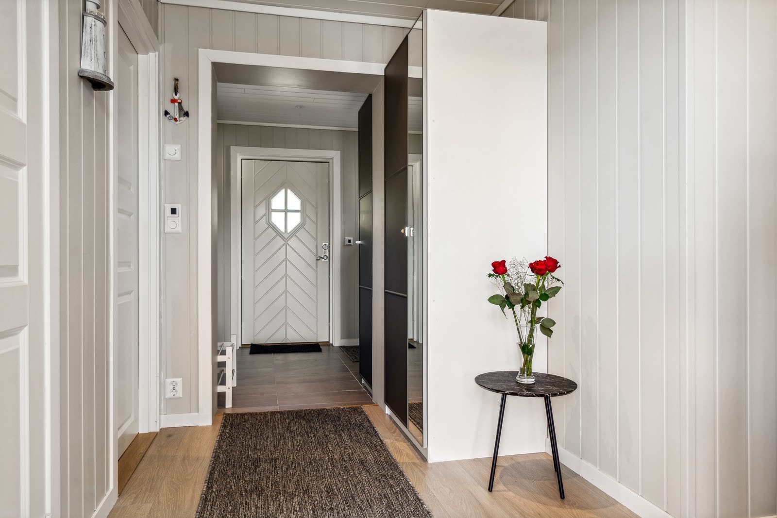 Jakker og sko ryddes enkelt bort i et stort garderobeskap med dels speilfronter. Galleribilde