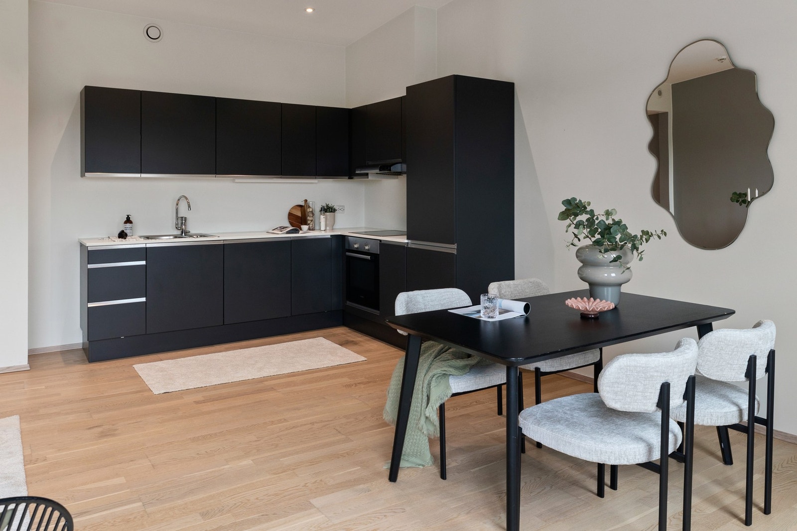 Kjøkkenet har en moderne mørk innredning med integrerte hvitevarer Galleribilde