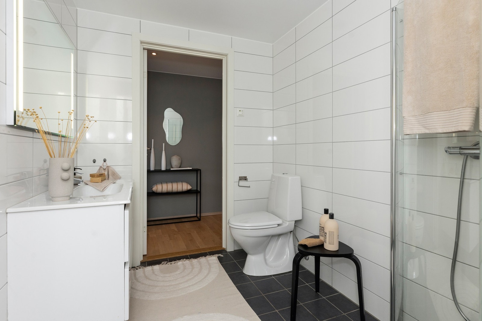 Det er utstyrt med frittstående toalett, servantinnredning og dusjhjørne Galleribilde