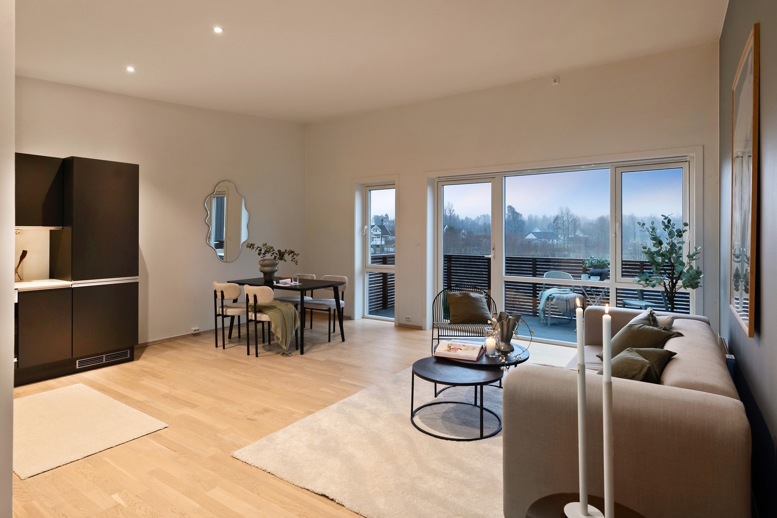 Det er åpen løsning mellom stue og kjøkken som skaper en sosial atmosfære i leiligheten Galleribilde