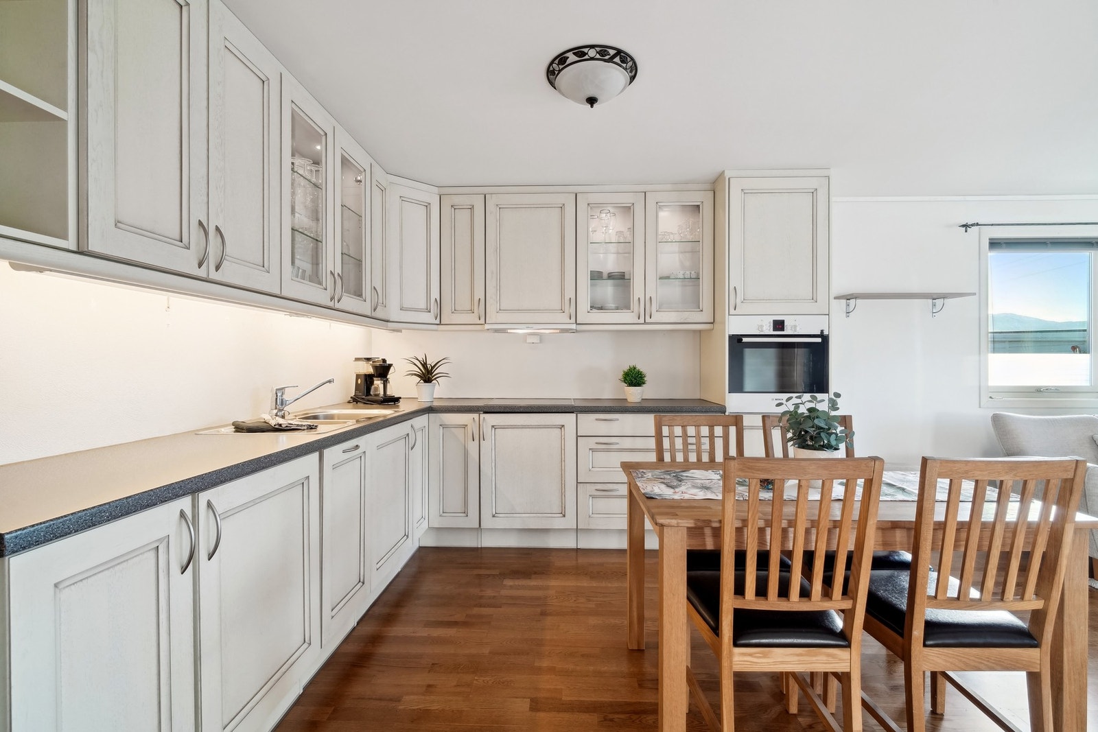 Det er laminat benkeplate og belysning under overskap. Lyst og pent med god plass til spisebord. Galleribilde