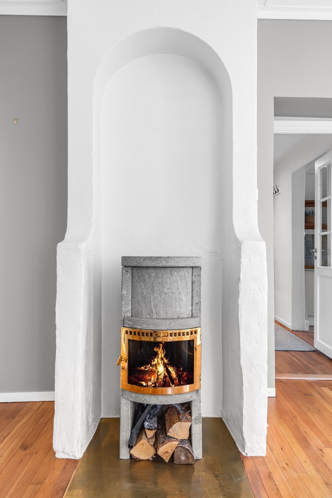 Pen og effektiv peisovn i kleberstein med glassdør i stuen. Galleribilde