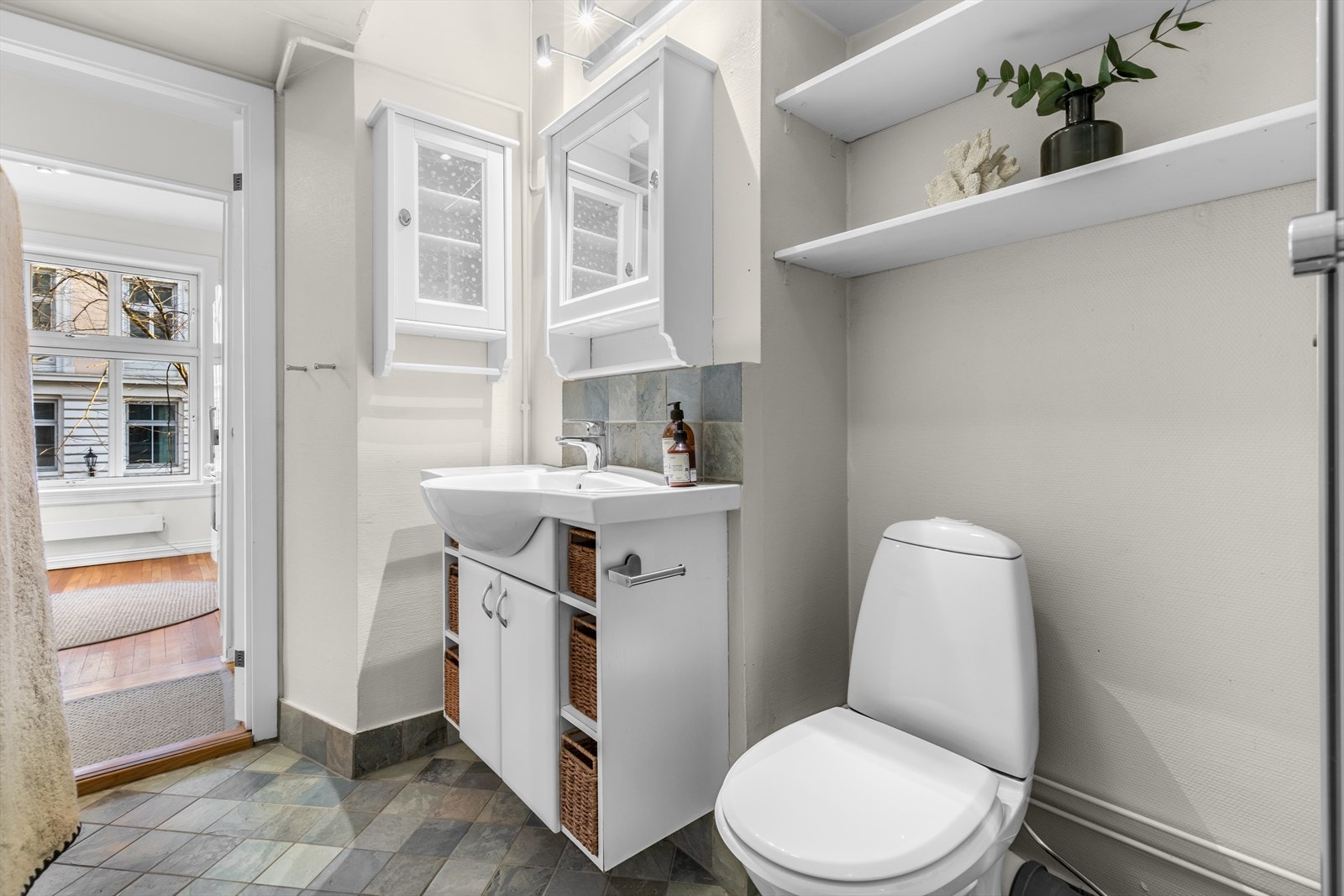 Flislagt og tapetsert bad med servant og wc. Galleribilde