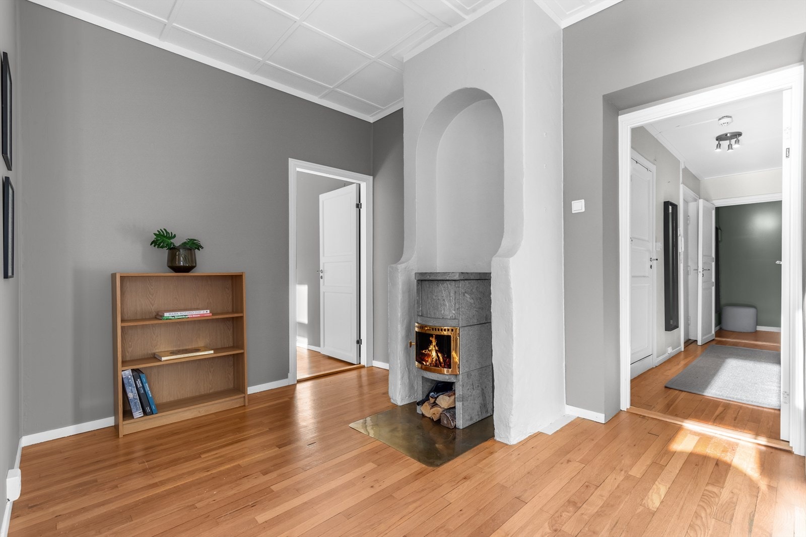 God plass til bokhylle og lenestol ved peisen. Galleribilde