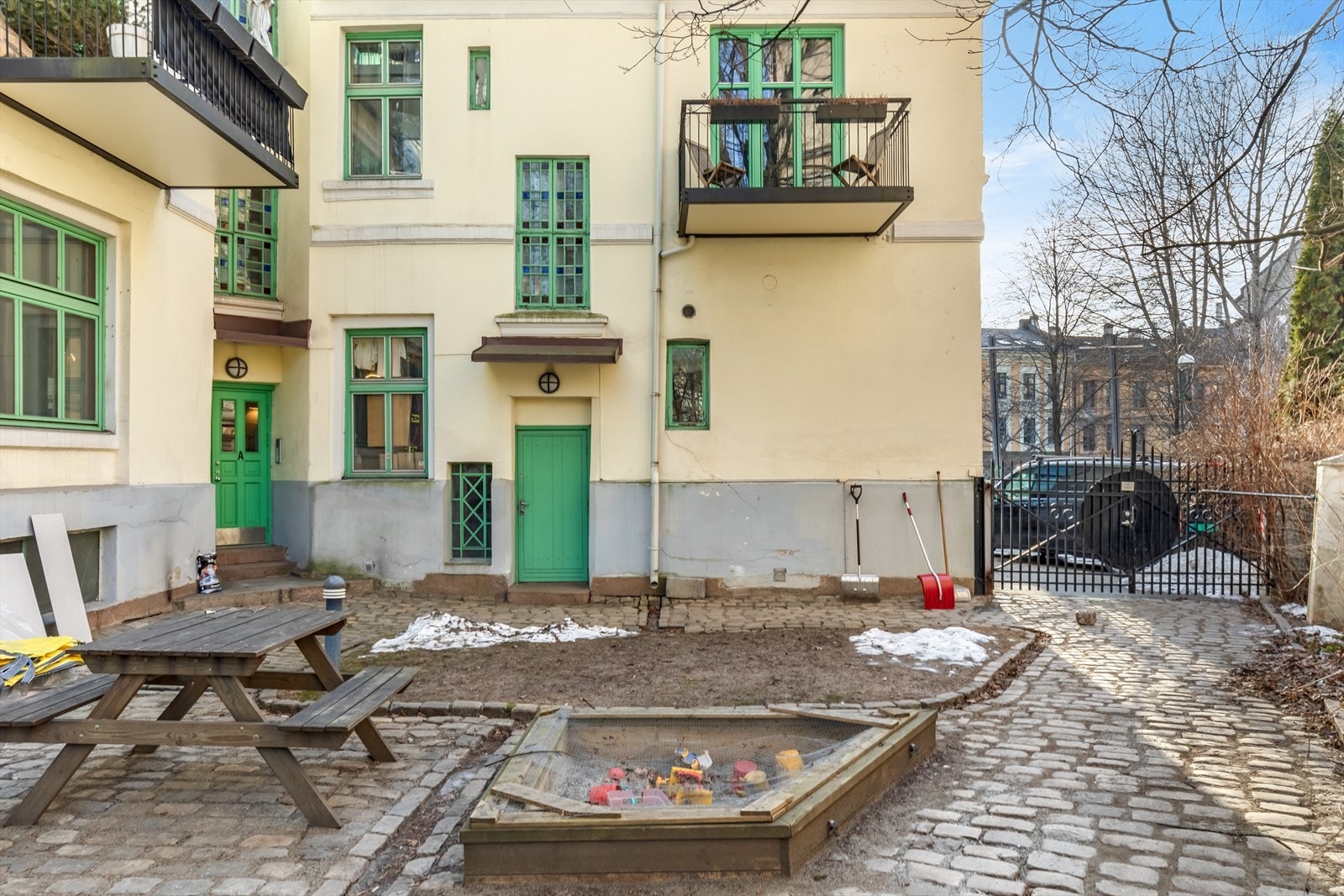 Klassisk bygård med lukket brosteinsbelagt bakgård. Sandkasse, sittegruppe og utebelysning. Galleribilde