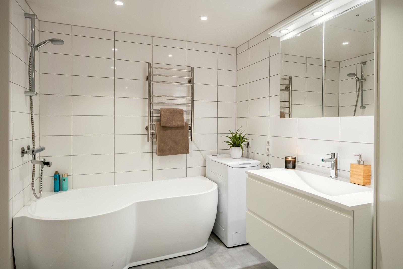 Smakfullt bad med flislagte overflater, gulvvarme og downlights. Galleribilde