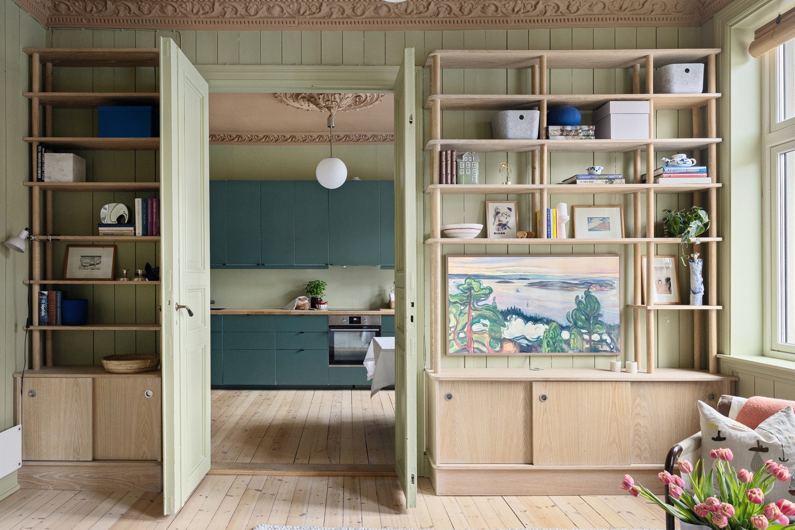 På stueveggen er det en møbelsnekret hylle-løsning som gir særpreg til rommet og godt med hylleplass. Galleribilde