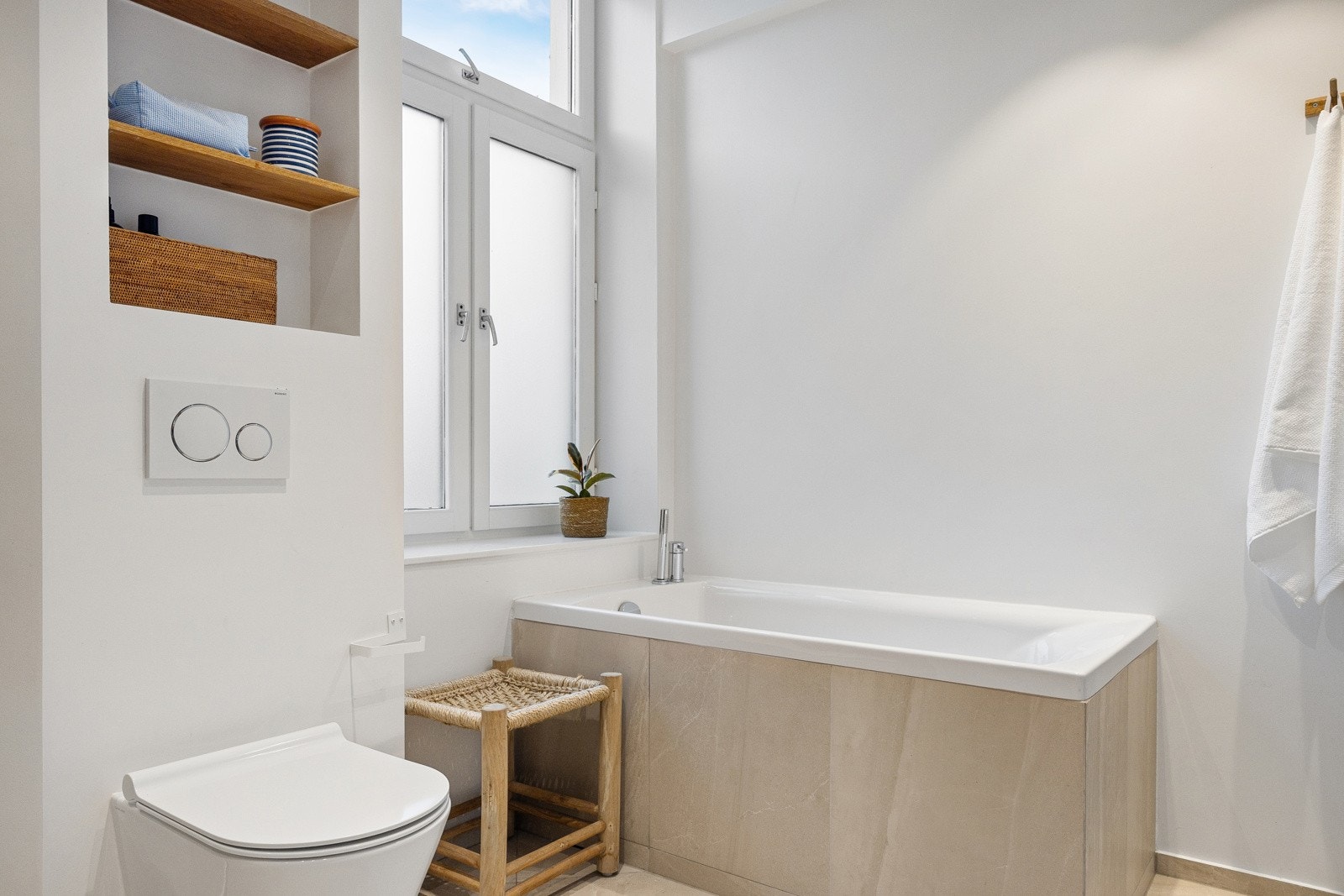 Badet er utstyrt med vegghengt toalett, en nedsenket dusjsone med regnfallsdusj og et romslig badekar. Galleribilde