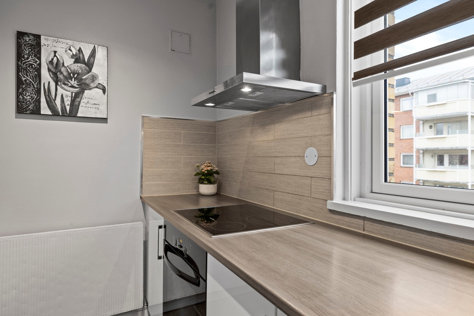 Kjøkkenet er utstyrt med integrerte hvitevarer som platetopp, komfyr og mikrobølgeovn Galleribilde