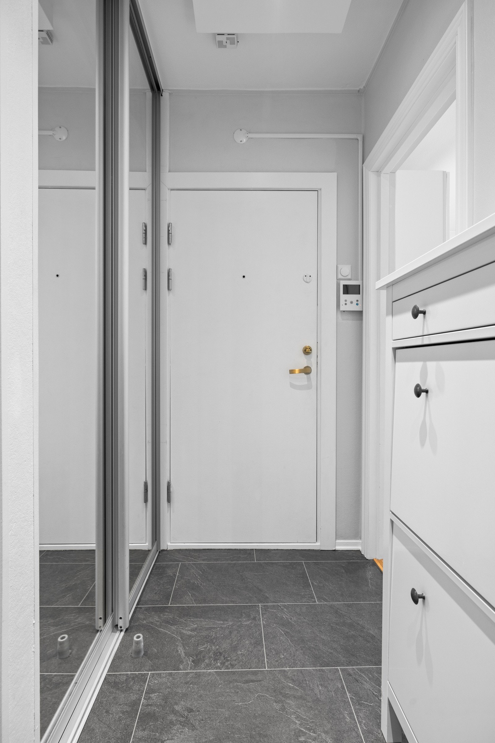 Entréen har en skyvedørsgarderobe med speilfronter, for praktisk oppbevaring av yttertøy Galleribilde